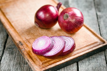 Fresh organic red onions on a wooden backgroundの写真素材