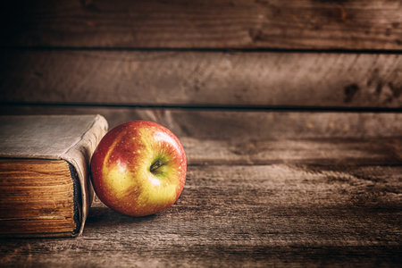  book and apple on the wooden tableの写真素材