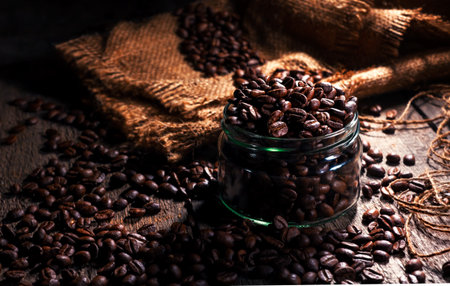 Coffee beans in a glass jar, black backgroundの写真素材