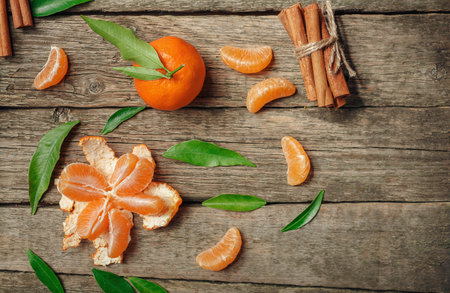 Tangerines with leaves and cinnamon stick on old wooden table. Top view.  Selective focusの写真素材