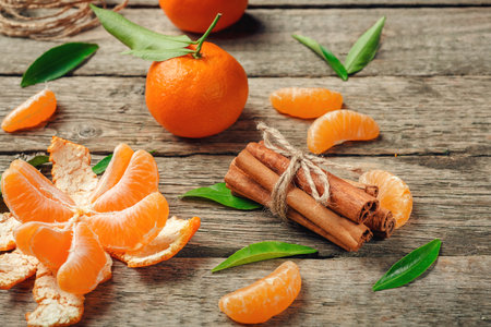Tangerines with leaves and cinnamon stick on old wooden table. Top view.  Selective focusの写真素材