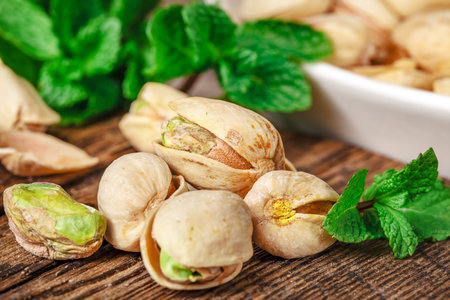 Bowl with pistachios on a wooden table.の写真素材