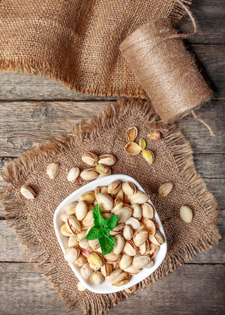 Pistachios nuts in bowl. Food mix background, top view, copy space, banner.の写真素材
