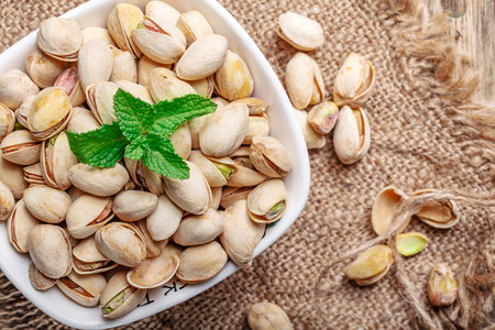 Some whole Pistachios (selective focus; close-up shot) on wooden background top viewの写真素材
