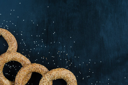 Turkish simit bagel dusted with sesame seeds on a black background. View from above. Banner background with copy spaceの写真素材