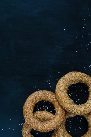 Turkish simit bagel dusted with sesame seeds on a black background. View from above. Banner background with copy spaceの写真素材