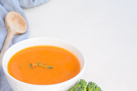 Pumpkin cream soup on a white table. Thyme Napkin Broccoli Spoon. Copy spaceの写真素材