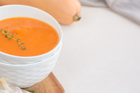 Pumpkin cream soup on a white table. Board Thyme Garlic Napkin Pumpkin. Copy spaceの写真素材