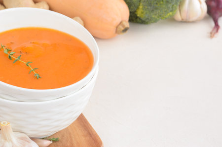 Pumpkin cream soup on a white table. Board Thyme Garlic Napkin Broccoli Pumpkin. Copy spaceの写真素材