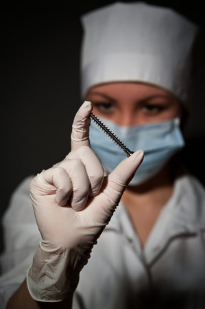 young pretty surgeon holding nail for osteosynthesis close upの写真素材
