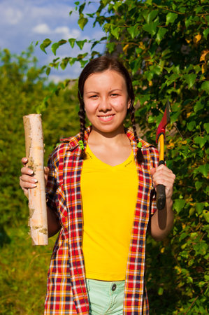young woman holding an axe and chock in the forestの写真素材