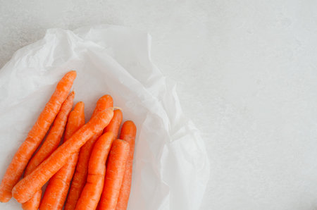 Fresh young carrots with copy space on light countertopの写真素材