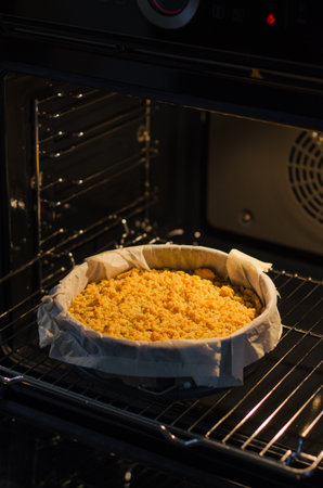 Close up of freshly baked sbriciolata crumble pie with plum jam baking in the ovenの写真素材