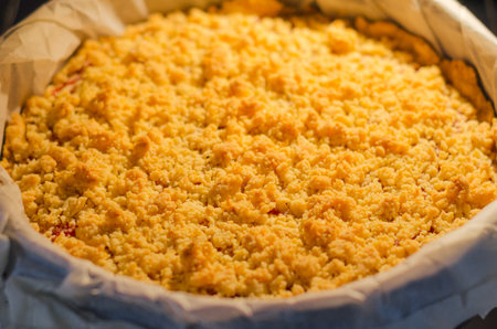 Close up of freshly baked sbriciolata crumble pie with plum jam baking in the ovenの写真素材