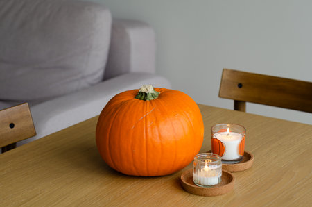 Minimal autumn table decor with pumpkin and candles for Halloween and Thanksgivingの写真素材