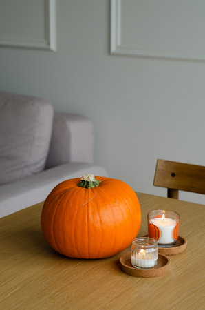 Minimal autumn table decor with pumpkin and candles for Halloween and Thanksgivingの写真素材