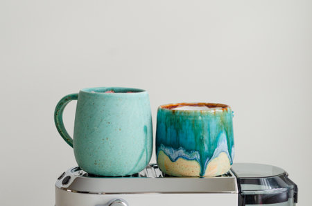 Cozy morning with turquoise cups warming on white portafilter coffee machineの写真素材