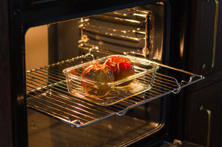 Two golden baked farm apples in a rectangular glass dish, healthy sugar-free dessert or diet-friendly snackの写真素材