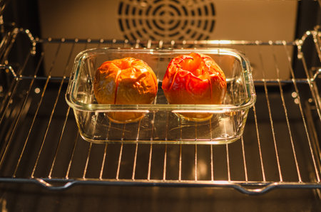 Two golden baked farm apples in a rectangular glass dish, healthy sugar-free dessert or diet-friendly snackの写真素材