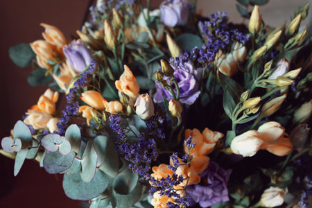 Bouquet with yellow small roses and purple decorative flowers close-up. Delicate bouquet for birthday cards, World Women's Day, flower shop, floral coursesの写真素材