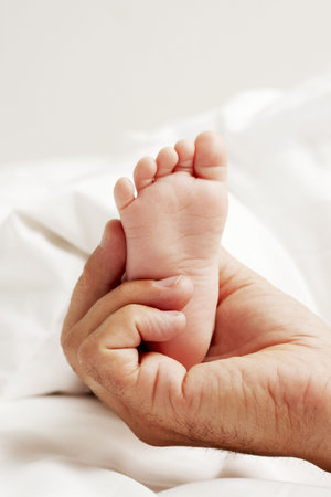 Dad holding baby feetの写真素材