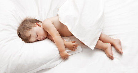 Baby sleeping in bedの写真素材