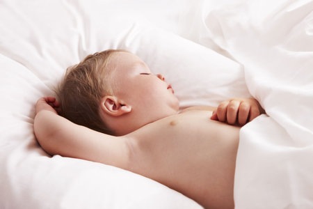 Baby sleeping in bedの写真素材