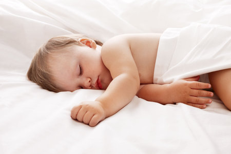 Baby sleeping in bed looking beautifulの写真素材