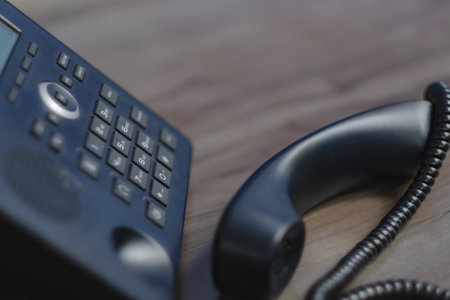 Closeup ip phone black color on the wood floor, Business connection conceptの写真素材