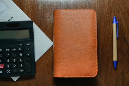 Calculator and note book for income, expenses, and income.
