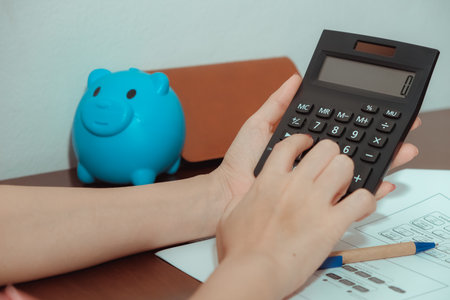 A close-up of a picture of a woman pressing a calculator,Business and finance concept.の写真素材