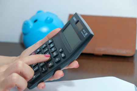 A close-up of a picture of a woman pressing a calculator,Business and finance concept.の写真素材