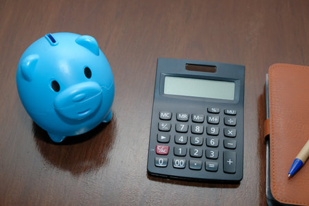 Piggy bank calculator with deposit put account on wood table.,Business and finance concept.の写真素材