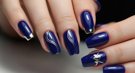Female hands with a dark blue manicure with silver lines and chrome details, macro shotの素材