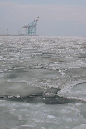 Snow-covered Black sea shore at sunrise.Snow, ice, frozen water. Soft sunlight. Picturesque winter scenery. Seasons, nature, environment, climate change, global warming themesの写真素材
