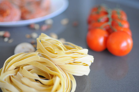 pasta with tomatoes and basil on a white background. Fork with pasta flying on a white background with tomatoes. High quality photoの写真素材