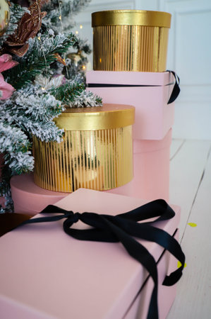Pink present boxes with ribbons under the Christmas tree in Classic apartments with white interior. High quality photoの写真素材