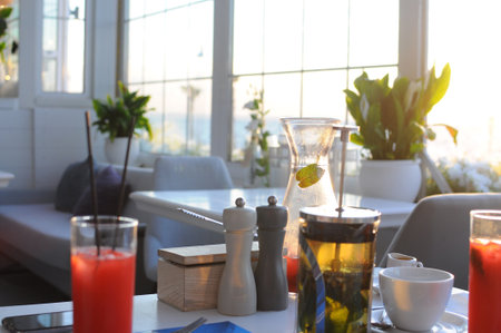 Beautiful sunrise lighting in the morning with a hot coffee and Moka Pot close up with copyspace. Beautiful natural sun lighting bokeh and coffee cup in the morning. High quality photoの写真素材