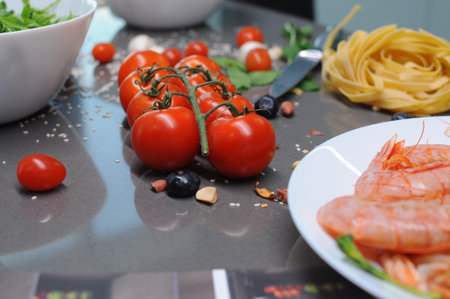 Spaghetti and fettuccine with ingredients for cooking pasta on wooden table with blank of round wooden kitchen board, top view. Rustic style. Flat lay. High quality photoの写真素材