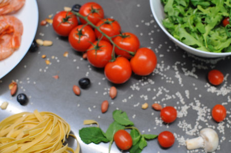 Spaghetti and fettuccine with ingredients for cooking pasta on wooden table with blank of round wooden kitchen board, top view. Rustic style. Flat lay. High quality photoの写真素材