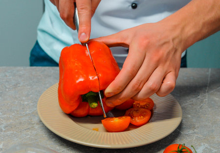 Closeup of hands of chef cook cutting vegetables on wooden table . High quality photoの写真素材