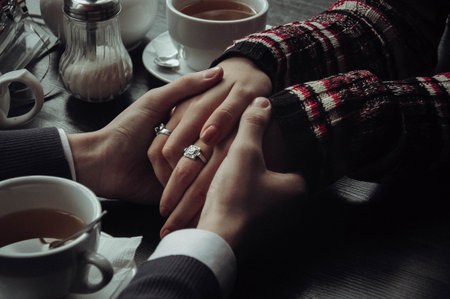 Close up of young couple hold hands talking sharing secrets showing love and care, husband and wife have tender close moment together, demonstrate support and understanding. High quality photoの写真素材