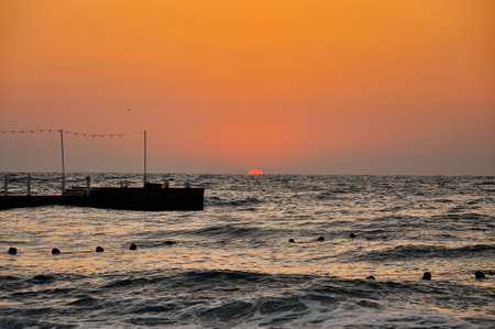Sunset at the beach. Cloudy sunset and pier. High quality photoの写真素材