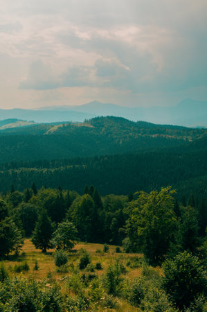 Beautiful green mountains with cloudy sky background. Summer vacation. Mountain landscape.の写真素材