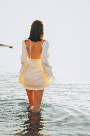 Beach holiday - woman walking on sunny, tropical beach in the morningの写真素材