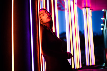 Glamour in neon illumination. Portrait of woman neon lights in background.の写真素材