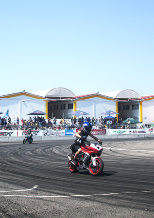 Biker in a black uniform driving a red sports motorcycle on a curvy roadの写真素材