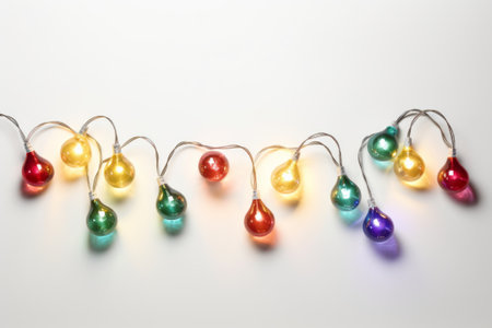 String of colorful Christmas garland lights isolated on white background.の素材