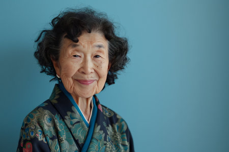 Smiling elderly Japanese woman on pale blue color background.の素材