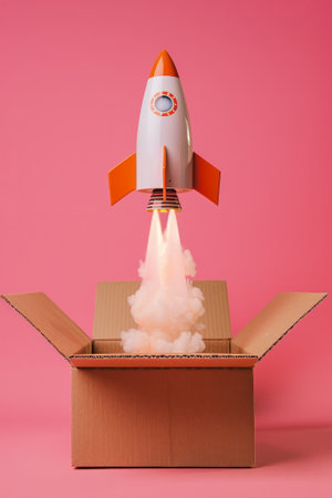 Tiny rocket is taking off from a cardboard box, pink background.の素材